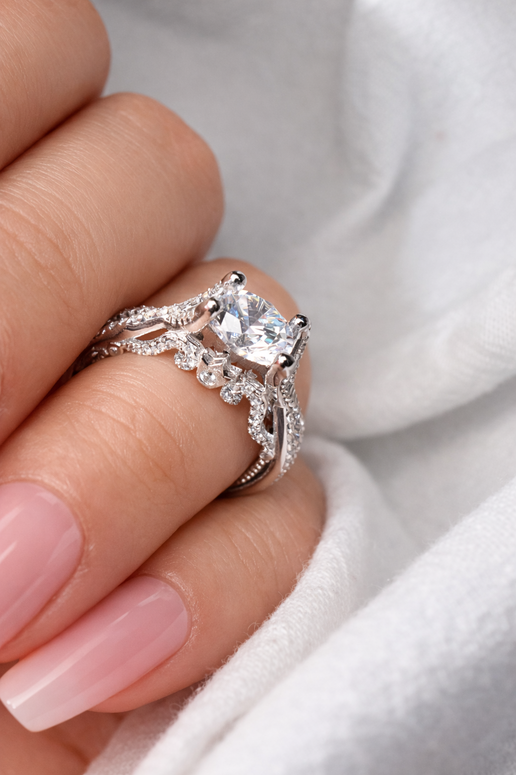 Silver ring with a large diamond on a finger against a white background
